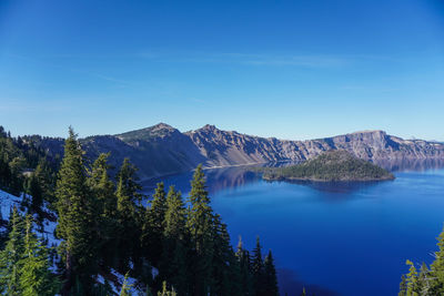 Scenic view of lake and mountains against blue sky