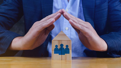 Midsection of businessman playing with toy blocks on table