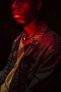 Close-up portrait of young man against black background