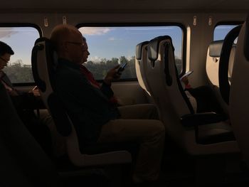 Side view of people traveling in train