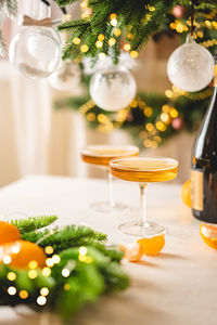 Champagne and tangerines in glasses on table