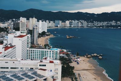 High angle view of sea and buildings against sky