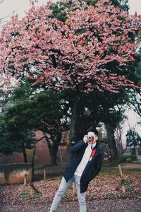 Young man with camera standing at park during winter