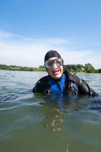 Happy man scuba diving in sea against sky