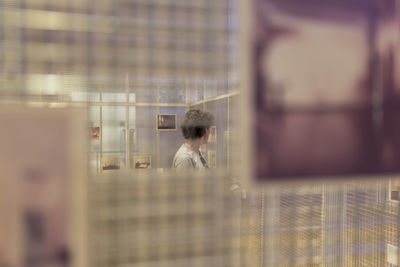 Portrait of man looking through display grid