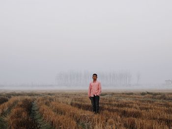 Full length of man standing on field against sky