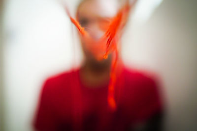 Close-up portrait of woman standing against blurred background