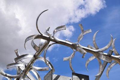 Low angle view of metal against sky