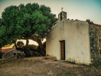 Exterior of old building by trees against sky