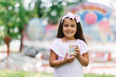 Cute little girl in the summer in the park holding popcorn in her hands