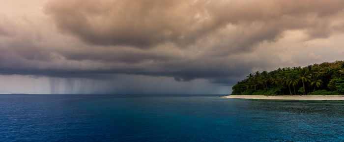 Scenic view of sea against storm clouds