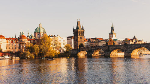 Arch bridge over river against buildings in city
