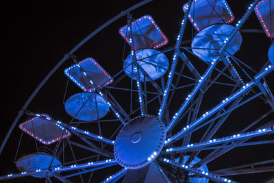 Low angle view of illuminated ferris wheel against sky at night