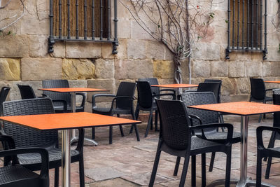 Empty chairs and table at sidewalk cafe