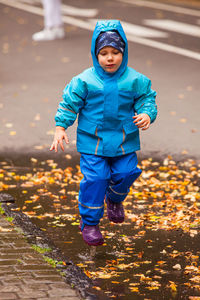 Full length of boy playing in puddle