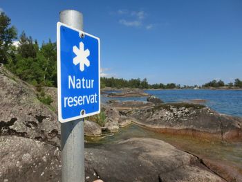 Information sign on road against blue sky