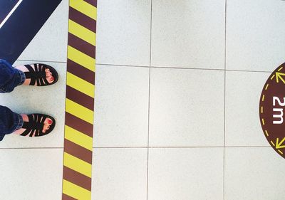 Low section of woman standing on tiled floor