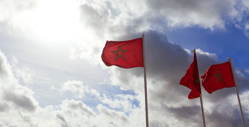 Low angle view of flag flags against sky