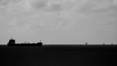 Silhouette ship sailing on sea against sky