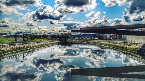 Bridge over river in city against sky