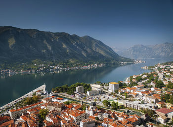 High angle view of townscape by lake against sky