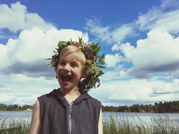 Portrait of happy boy standing against sky