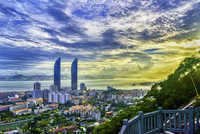 View of cityscape against cloudy sky