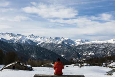 Rear view of person on snowcapped mountains against sky