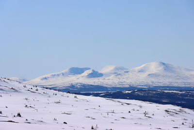 Scenic view of snowcapped mountains against clear blue sky