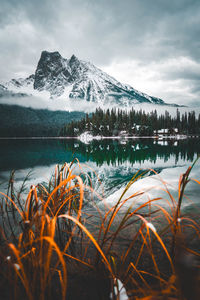 Scenic view of lake by snowcapped mountains against sky