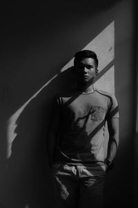 Young woman standing against wall