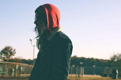 Midsection of woman standing against sky during sunset