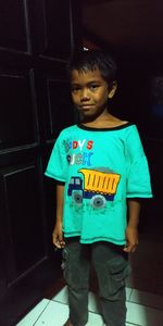 Portrait of boy standing against wall