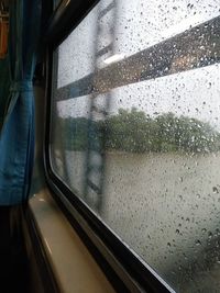 View of train through window in rainy season