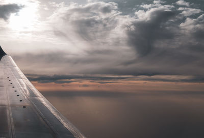 Airplane flying over cloudscape during sunset