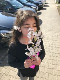 Portrait of young woman holding flowers