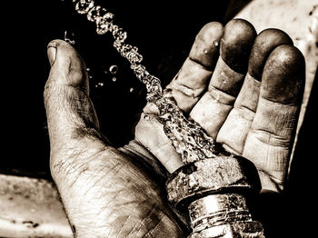 Close-up of human hand against black background