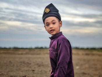 Portrait of boy standing on field