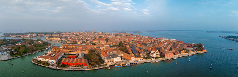 High angle view of city by sea against sky