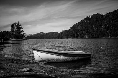 Boat moored in lake against sky