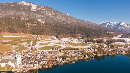 Aerial view of townscape by lake against sky