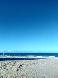 Scenic view of beach against clear blue sky