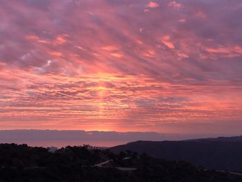 Scenic view of silhouette mountains against romantic sky at sunset