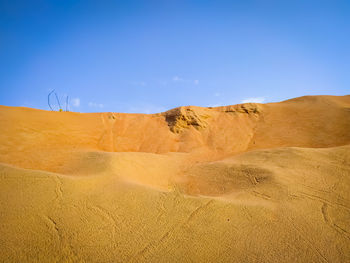 Scenic view of desert against clear blue sky