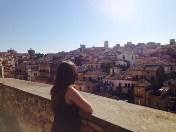 Rear view of woman looking at cityscape