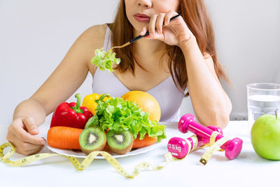 Midsection of woman holding fruits