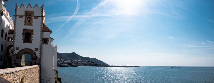 Panoramic view of sea by buildings against sky