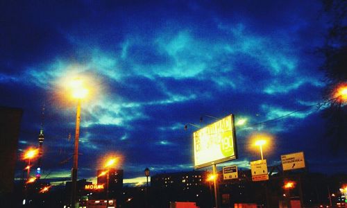 Low angle view of illuminated building against cloudy sky