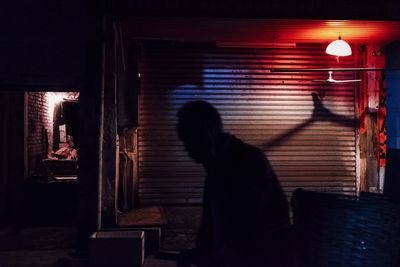 Rear view of people standing on street at night