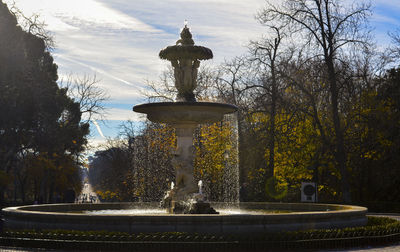 Fountain in city against sky